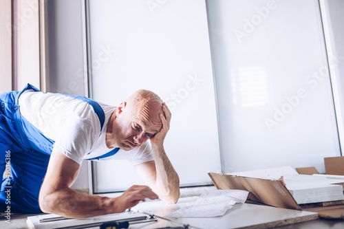 Nervous confused man assembling cabinet at home.