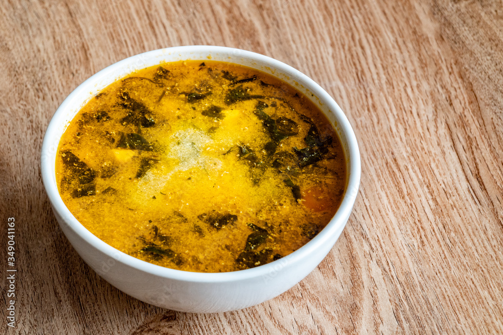 A bowl of soup. Soup of potatoes, spinach, carrots, meat. Close-up image.