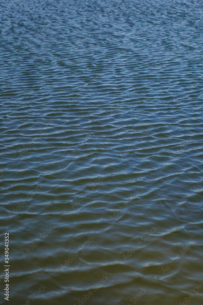 Beautiful surface of the water of the river and lake. Pond and waves from the wind in nature. Background for your design. Beautiful surface of the water of the river and lake. Pond and waves from the wind in nature. Background for your design.