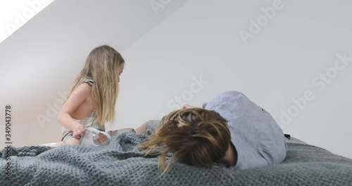 Sister tickling her brother on bed