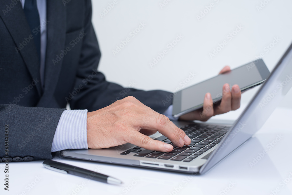 Businessman working on laptop computer and digital tablet Businessman working on laptop computer and digital tablet