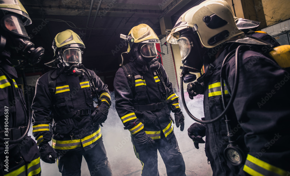Group of firefighters in the fire department checking their gas mask equipment Group of firefighters in the fire department checking their gas mask equipment