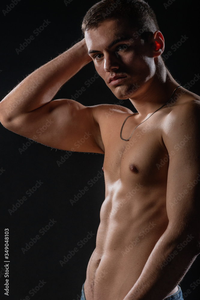 Portrait of a strong healthy handsome athletic man posing as a fitness model on dark background Portrait of a strong healthy handsome athletic man posing as a fitness model on dark background