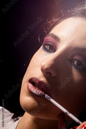 Beauty makeup. Young woman applying lip gloss