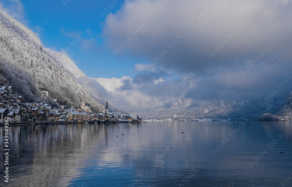 Obraz premium Image of cold and snowy winter in Austria. Beautiful mountain and nature at Hallstatt near Obertraun city opposite the Hallstatter See lake at foggy weather. January 2020