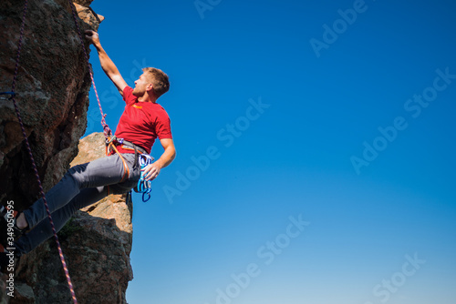 Young man finishing his extreme mountain climb