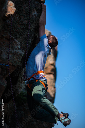 Rockclimber climbing up a steep piece of mountain