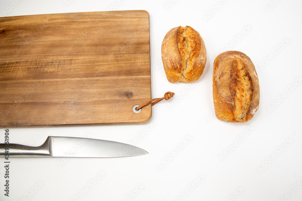Flat lay packshot chleb z deską, nożem i maselniczką bochenek domowego pieczywa na dużej desce do krojenia - obrazy, fototapety, plakaty 