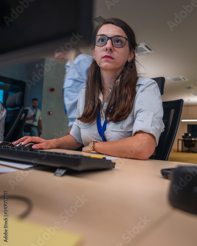 Female security guards working on computers while sitting in the main control room