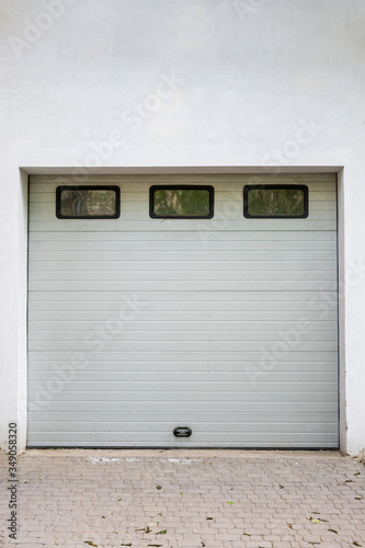 White garage door. Automatic gate with three windows