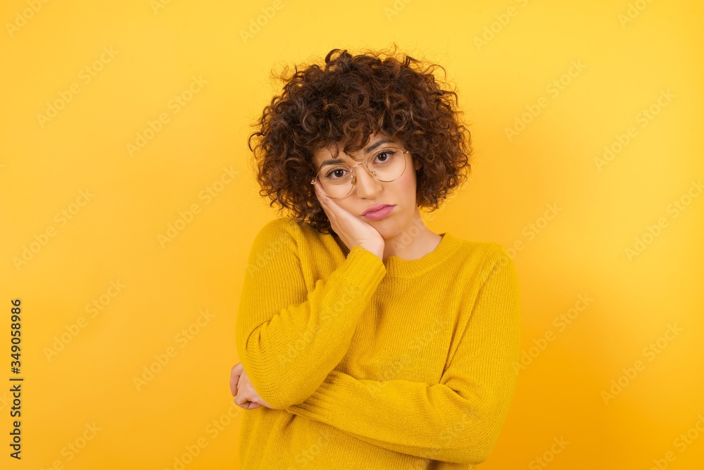 Very bored adult businesswoman holding hand on cheek while support it with another crossed hand, looking tired and sick, over white background. Very bored adult businesswoman holding hand on cheek while support it with another crossed hand, looking tired and sick, over white background.