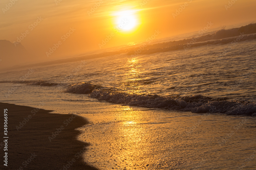 Fototapeta premium Sol sobre as ondas na areia da praia, beleza e tranquilidade