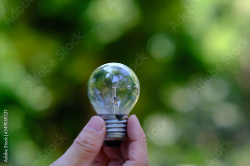 businessman holding a glowing light bulb on bokeh background