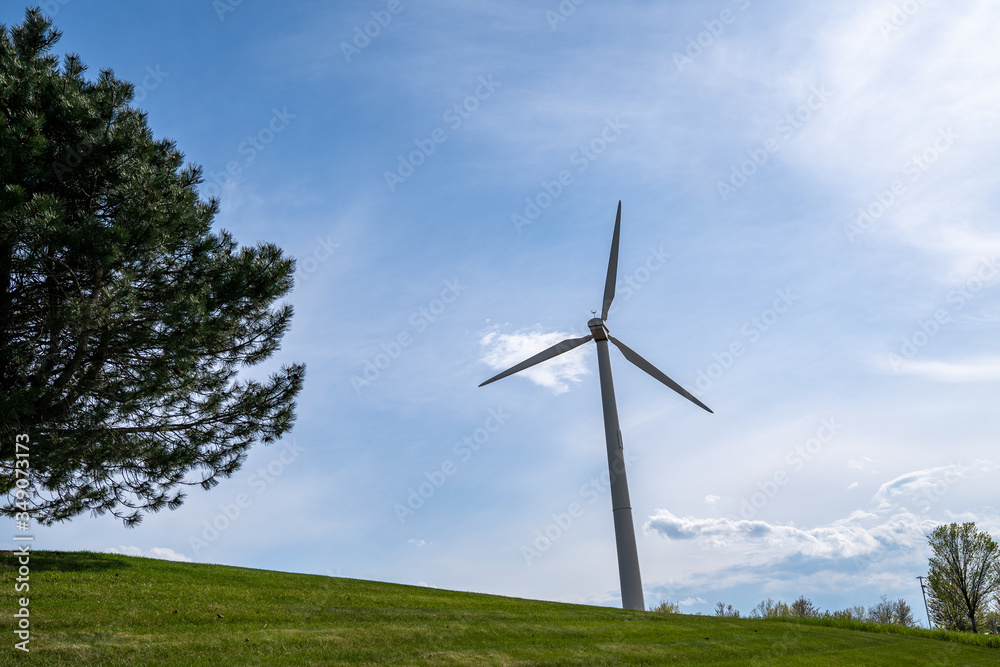 Wind turbine in Maple Grove, Minnesota, against a blue sky with clouds in a park Wind turbine in Maple Grove, Minnesota, against a blue sky with clouds in a park