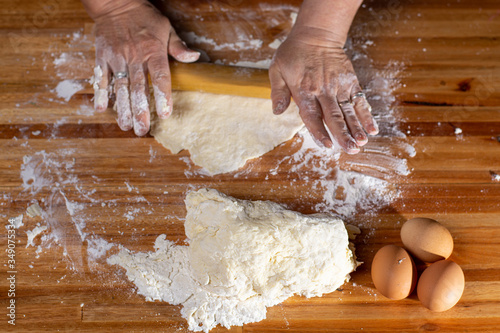 Vista cenital de manos amasando comida tradicional sobre mesa de pino