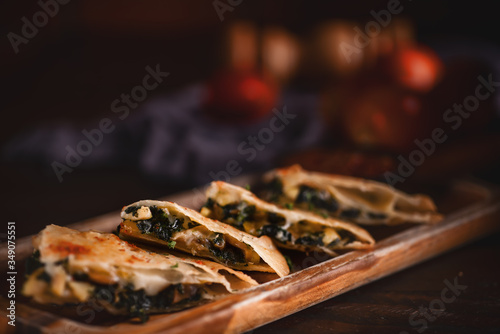 mexican food background of sliced chicken quesadilla with sauce in dark tone