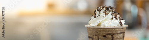 Closeup of takeaway plastic cup of coffee mocca frappe with whipped cream and chocolate sauce and chips with copy space. Using for cover page. photo