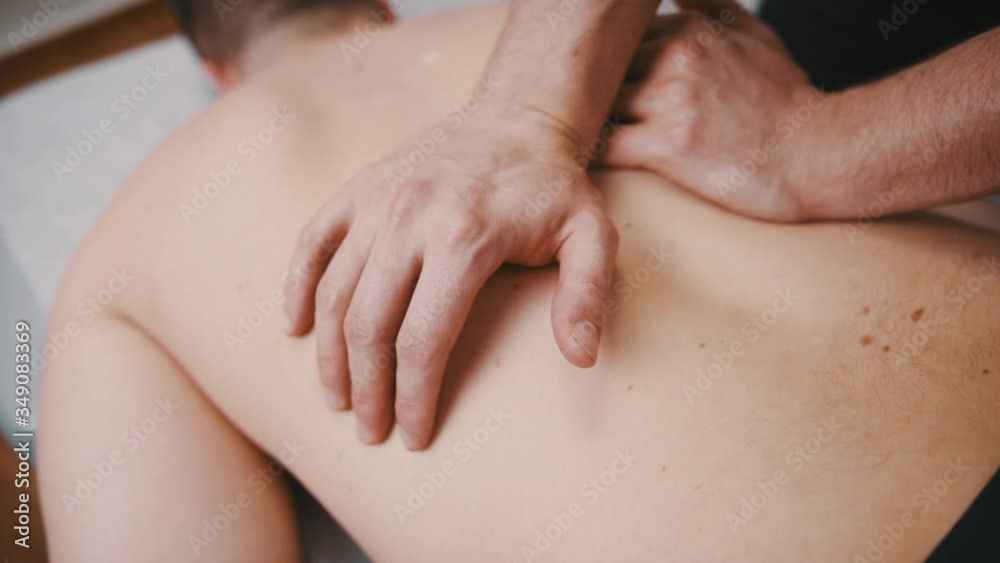 Physiotherapist giving back massage to patient, close up slow motion shot. Physiotherapist giving back massage to patient, close up slow motion shot.