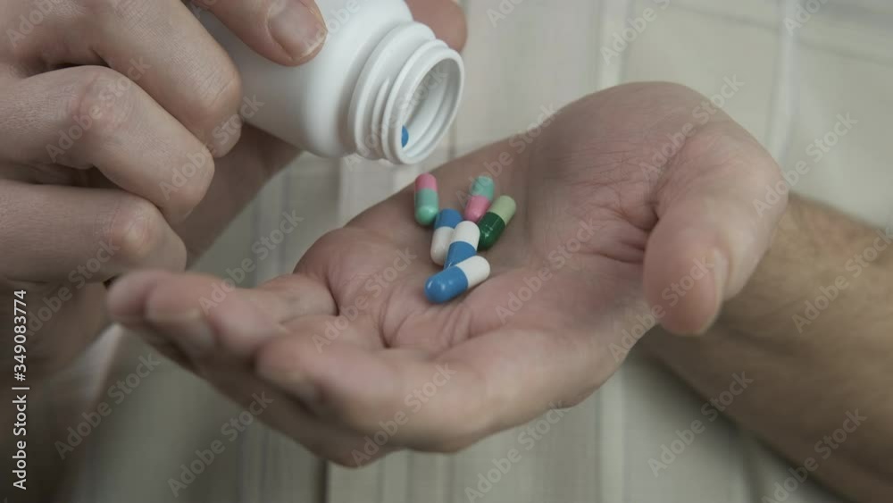 Pouring pills for suicide. The man pours a handful of granules into his hand. The suicide problem. Pouring pills for suicide. The man pours a handful of granules into his hand. The suicide problem.
