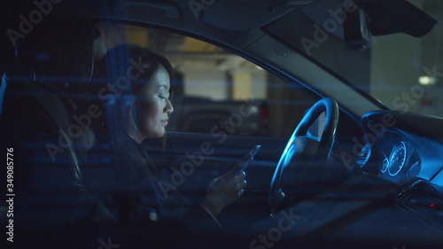 Woman in a car typing a message on the phone © iaginzburg