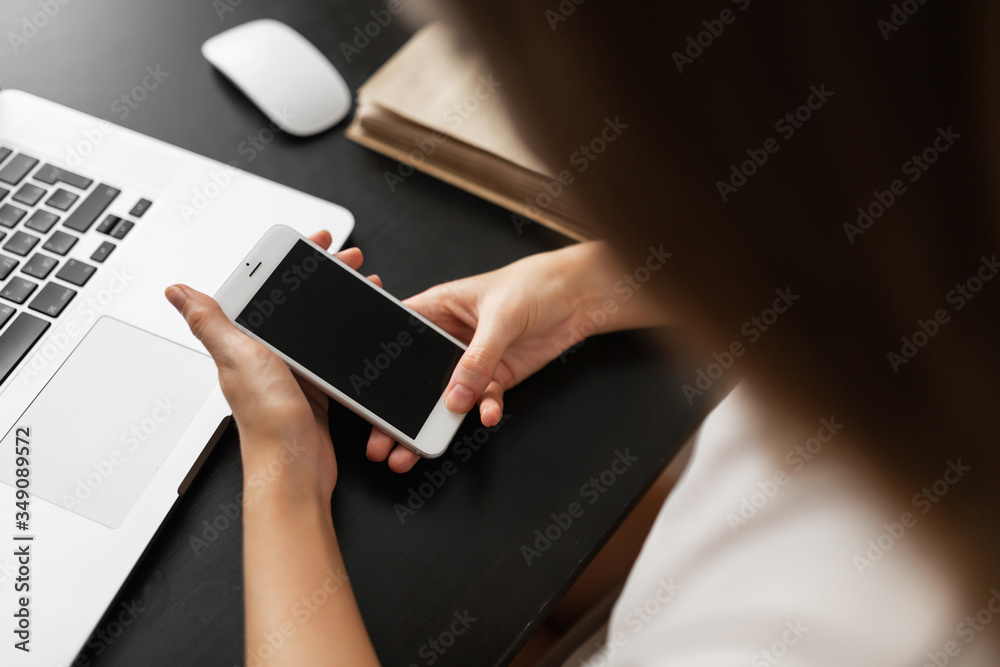 the girl does work from home, looks at information on the phone and checks it against information on the computer during quarantine and pandemic. clouse - up the girl does work from home, looks at information on the phone and checks it against information on the computer during quarantine and pandemic. clouse - up