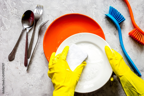 concept of woman washing dishes on gray background top view photo