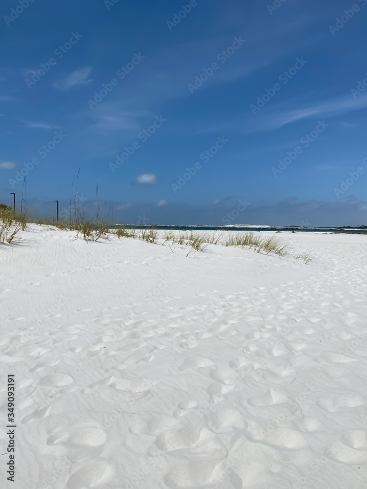 White sand beach with distant view of emerald colored water of the Gulf of Mexico White sand beach with distant view of emerald colored water of the Gulf of Mexico