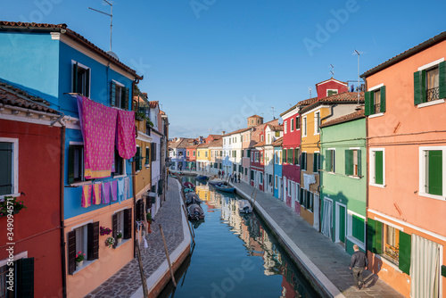 Panoramic view of Burano channel with hanged clothes and colorful houses, in Venice, Italy. © christian vinces