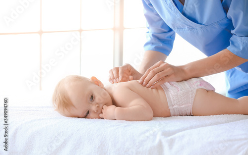 Massage therapist working with cute baby in medical center