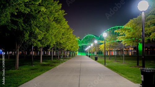 Tableau sur toile Walkway at Waterfront Park in Louisville, KY with the Big Four bridge in background lit green to mark those who have lost their lives to COVID-19