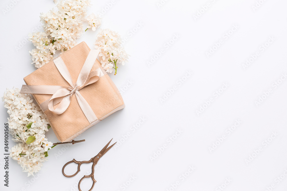Beautiful lilac flowers, gift and scissors on white background Beautiful lilac flowers, gift and scissors on white background