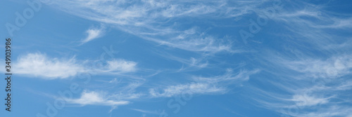 Beautiful wispy cirrus clouds in blue sky on freedom, energize and joyful sunny day, clean renewable energy concept