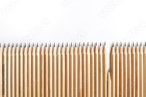 Row of even sharpened pencils made of wood stand next to each other