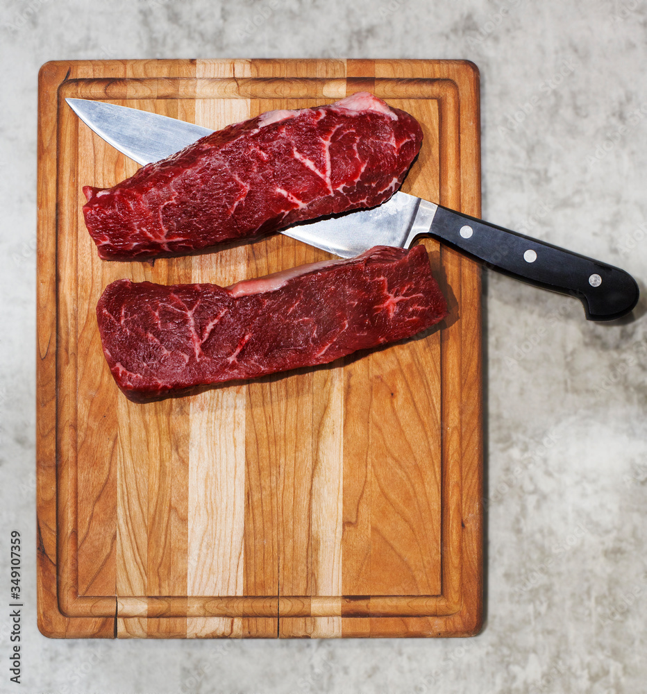 Raw striploin steak on woodencooking board, top view, copy space Raw striploin steak on woodencooking board, top view, copy space