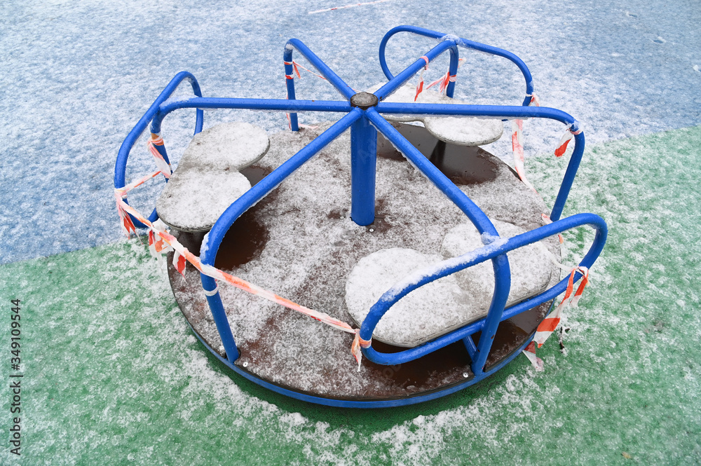 Children carousel locked during epidemic of COVID-19, snow around Children carousel locked during epidemic of COVID-19, snow around
