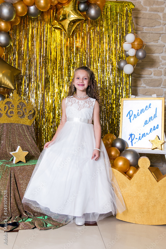 Portrait of girl princess in white dress with gold star