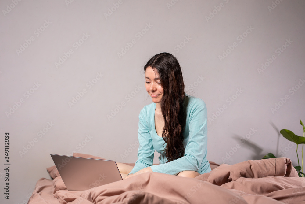 The concept of social distance and isolation. Work from home remotely over the Internet. A young woman works at home on a computer. Copy space. The concept of social distance and isolation. Work from home remotely over the Internet. A young woman works at home on a computer. Copy space.