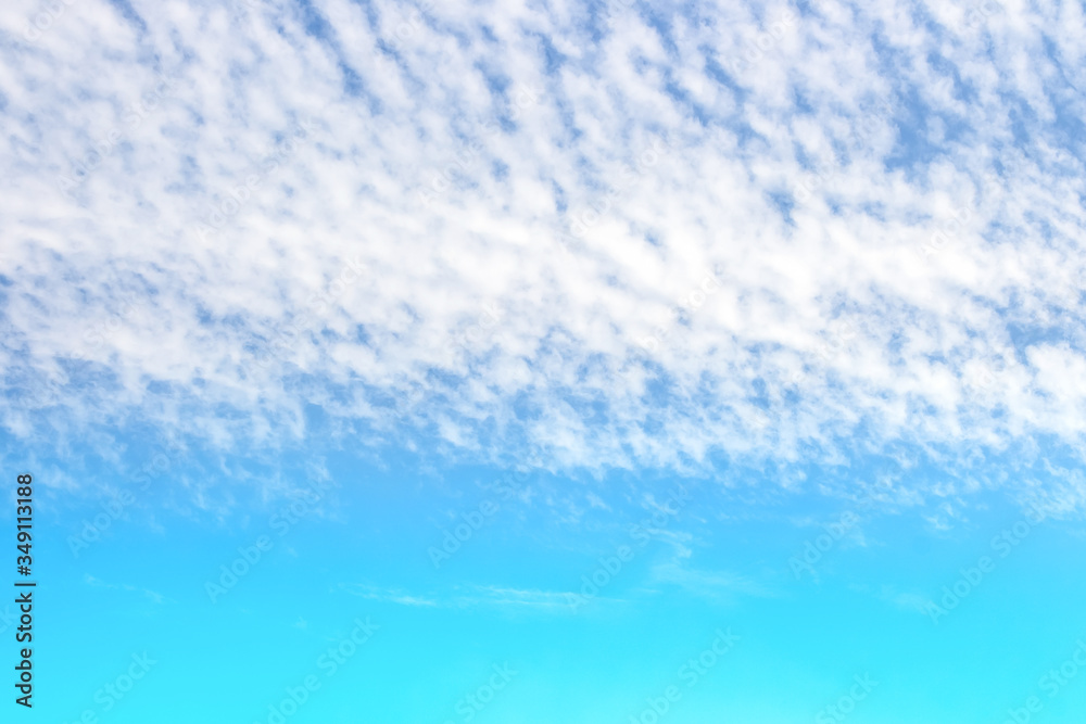 soft white clouds streak in colorful blue sky