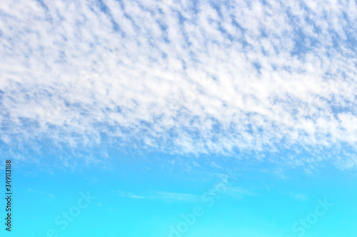 soft white clouds streak in colorful blue sky