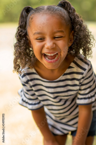 Cute mixed race little girl laughing and smiling.