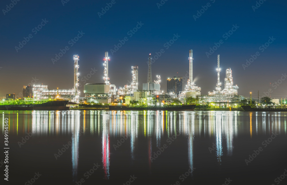 oil refinery industry plant light in twilight evening with a reflection in the river. Bangkok Thailand.