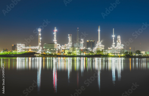 oil refinery industry plant light in twilight evening with a reflection in the river. Bangkok Thailand.