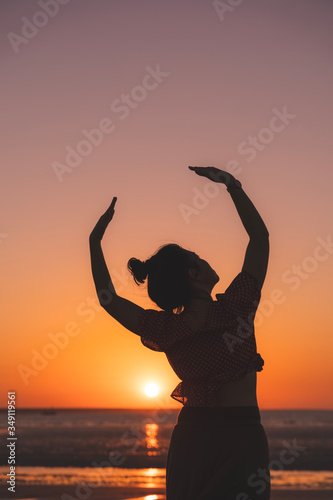 Dancer on the beach in the golden sunlight. Mindil Beach, Darwin, NT, Australia. photo