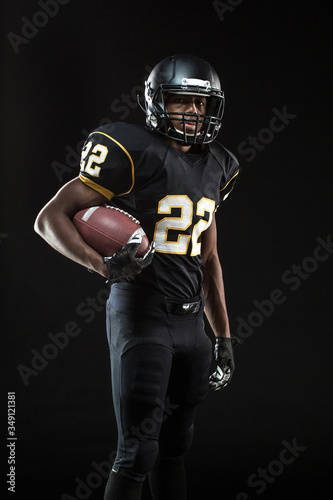 African American football player isolated on black.
