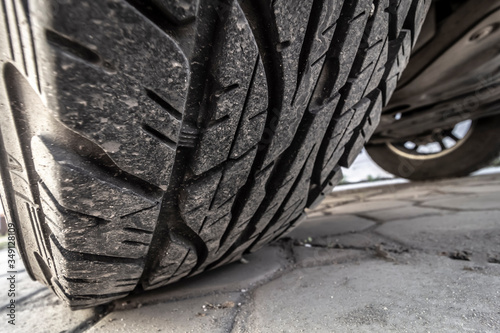 Tread of a wheel of an off-road car standing in the back yard, closeup.