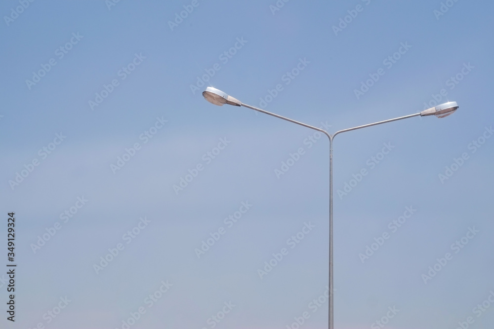 Street lighting bulb in daytime with blue sky close-up.