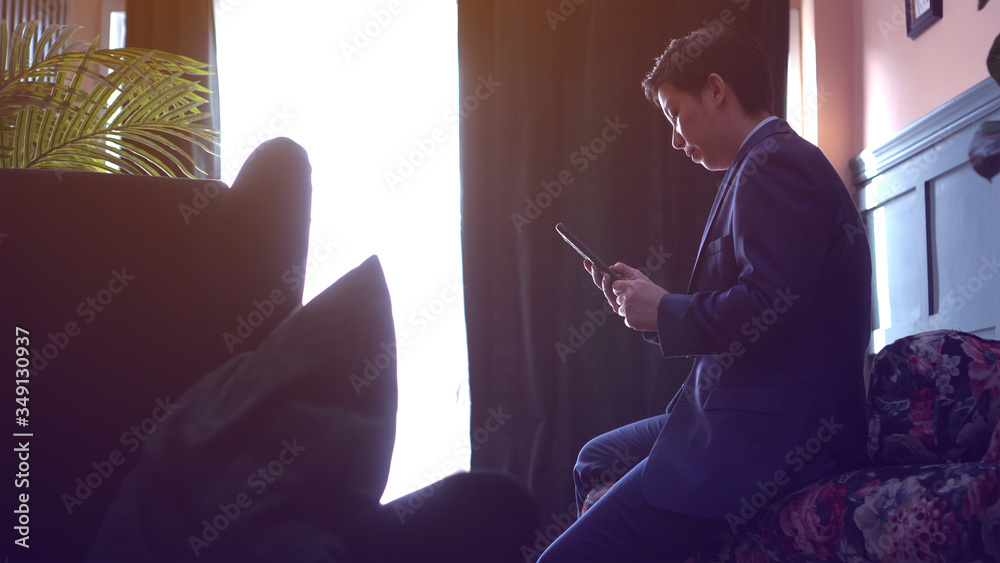 Asian executive manager  businessman in suit working through smartphone from luxury home unhappy