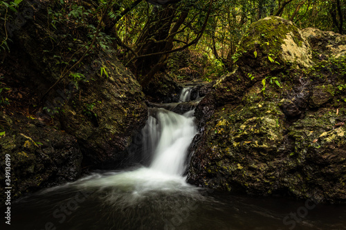 Fototapeta Naklejka Na Ścianę i Meble -  waterfall cover with green lush forest long exposure flat angle image