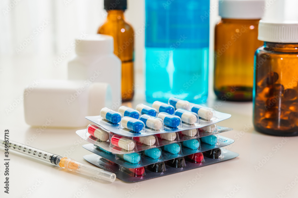 Medicine pills, tablets and capsules in packaging with syringe and dropper bottle on table. Medicine pills, tablets and capsules in packaging with syringe and dropper bottle on table.