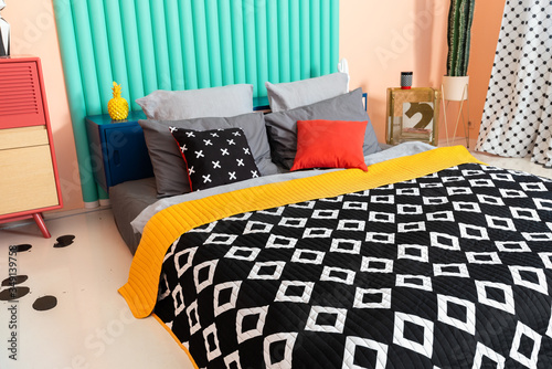 Modern colorful hipster unordinary bedroom with black and white textile and bright accents. photo
